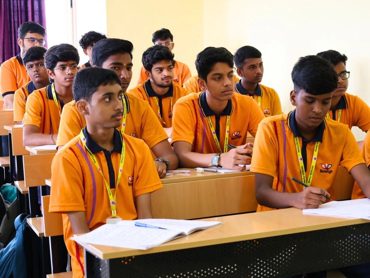 Teacher guiding students in a spacious well-lit classroom at NewAge PU College
