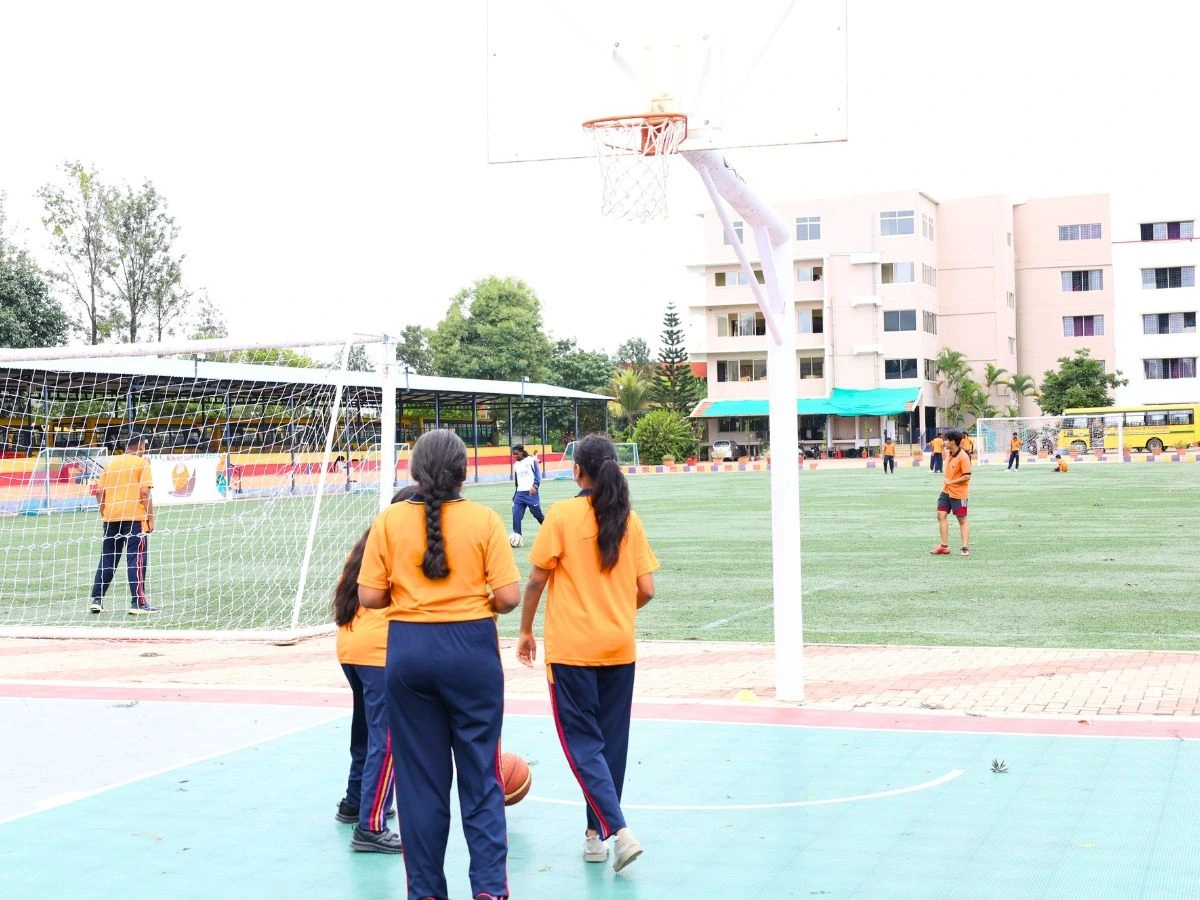 Students playing football on campus outdoor sports field